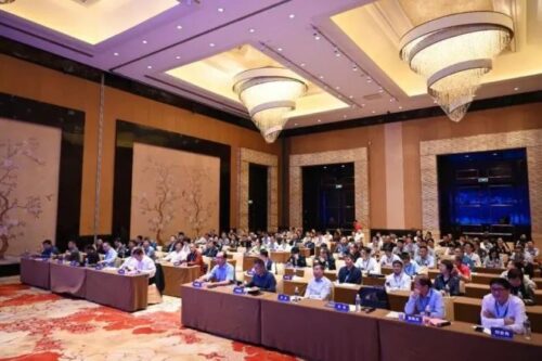 The picture shows the attending representatives listening to the meeting.